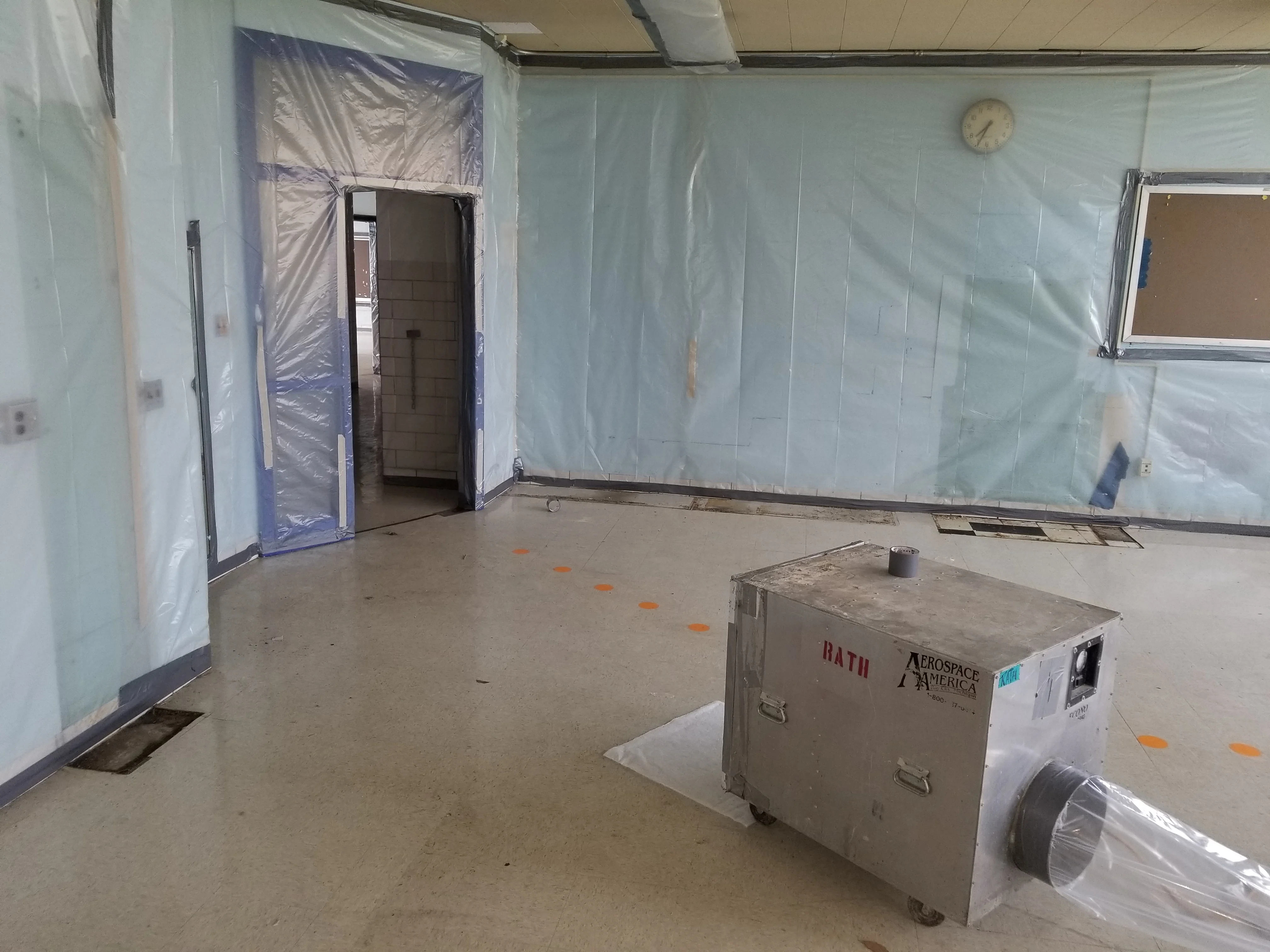Commercial asbestos abatement project with containment barriers and plastic sheeting